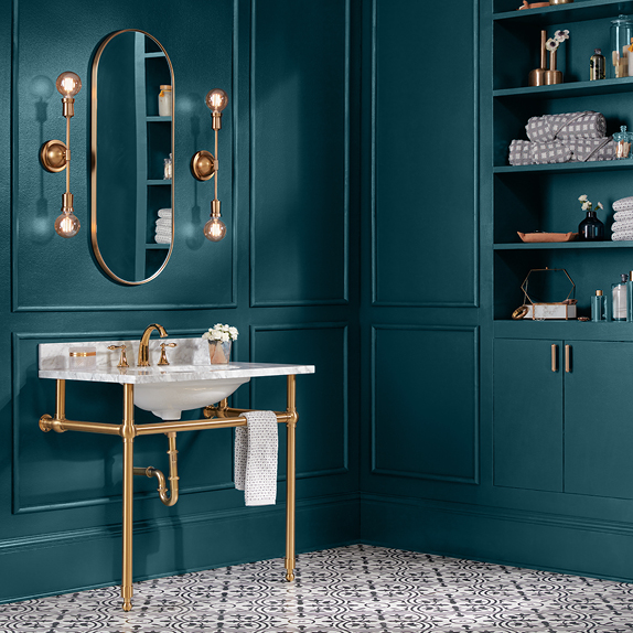 Monochromatic blue-green bathroom in Color of the Year, Everglade Deck, with brass fixtures and open linen shelves. 