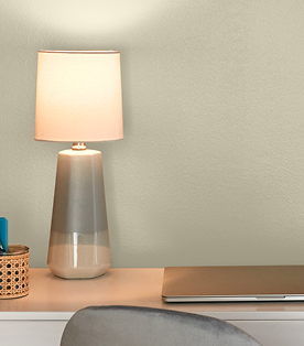 Bright lamp on white desk against Villa Grey, a warm neutral and 2023 Color of the Year. 