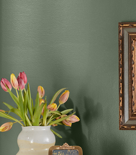 Overflowing tulips in a vase against a corner wall in deep olive, Flora color.
