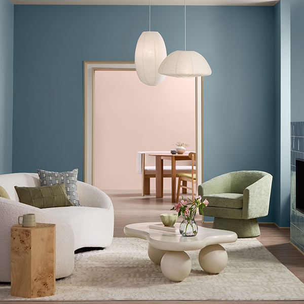Light-filled nursery featuring Cottage Door blue-gray walls, neutral furnishings, soft textiles, and warm wood accents for a calm, inviting atmosphere.
