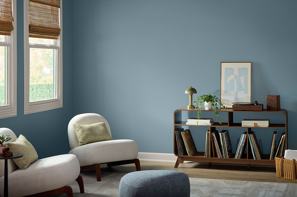 Contemporary living room with Cottage Door blue-gray walls, comfortable seating, layered textures, and warm wood furnishings for a relaxed, refined look.