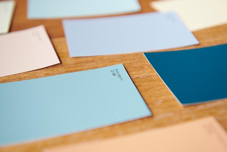 Blue and neutral color chips on a wood surface.