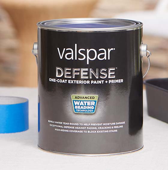 One-gallon can of Valspar® Defense® Paint and Primer sits next to roll of blue masking tape.