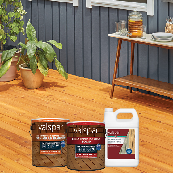 A porch with a wood floor, plus plants, a table with glasses on it and a lineup of Valspar Stain and Sealer products.