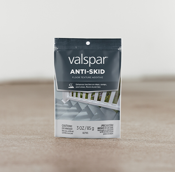 Pool with two different stone surfaces. Two cans of Valspar Porch, Floor & Patio with Heat Relief Technology in foreground.