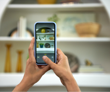 Hands hold phone pointed at shelves. In viewfinder can be seen plates, vases, etc. Title says, “Color Match.”