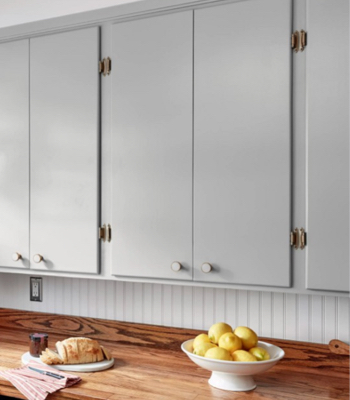 Granite Dust kitchen cabinets above wooden countertop with loaf of bread and bowl of lemons.