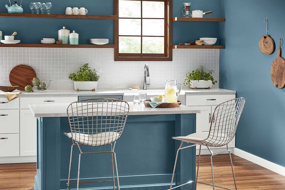 Soft teal kitchen walls and island contrast with white cabinetry, tile backsplash and open wood shelves.