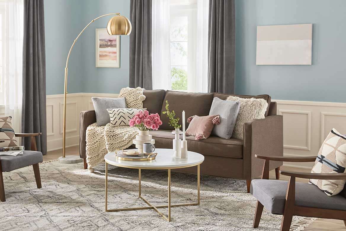 Contemporary living room with half wall paneling in neutral shade and soft blue-gray walls.