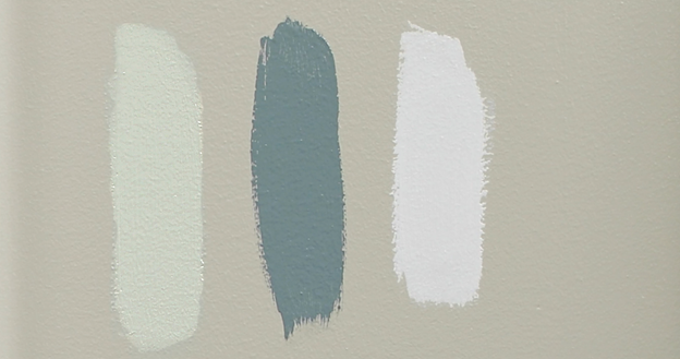 Blank tan wall with three color samples lined up in a row next to each other.