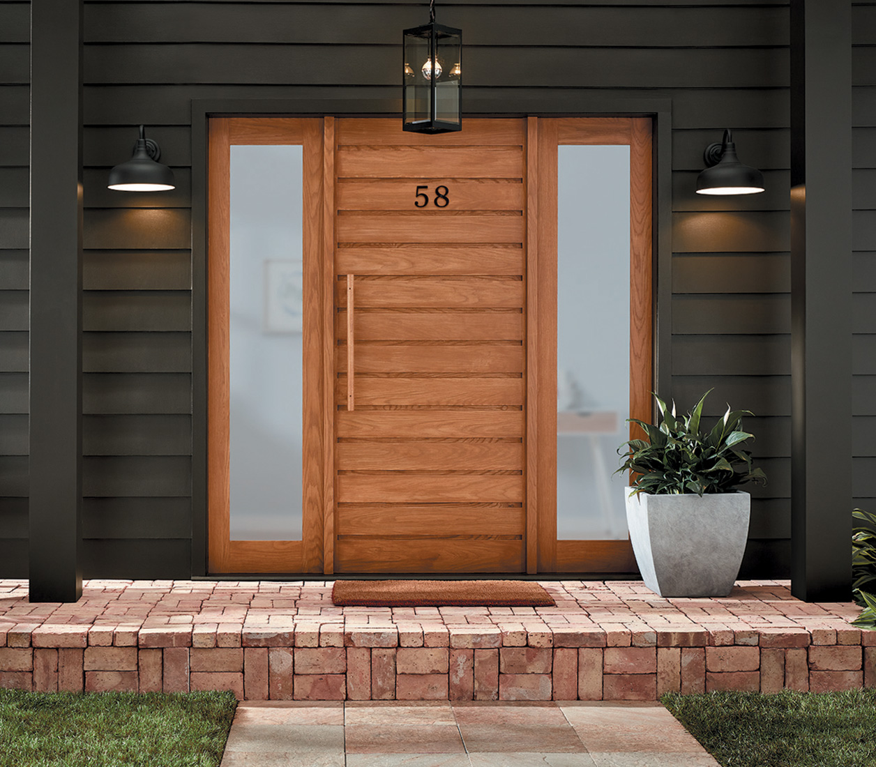 Exterior of door in Simply Cedar with outdoor lights on either side, a wood chair,  outdoor plant and brick porch.
